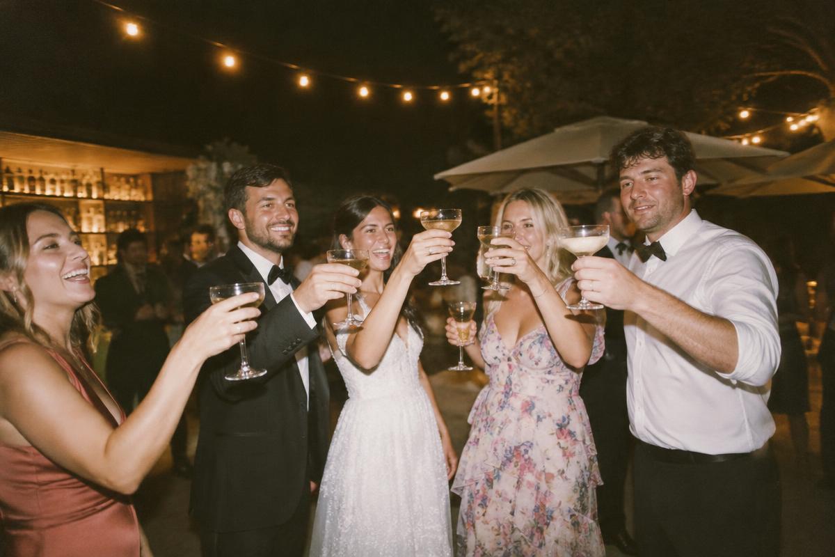 Wedding guests toasting under string lights late at night
