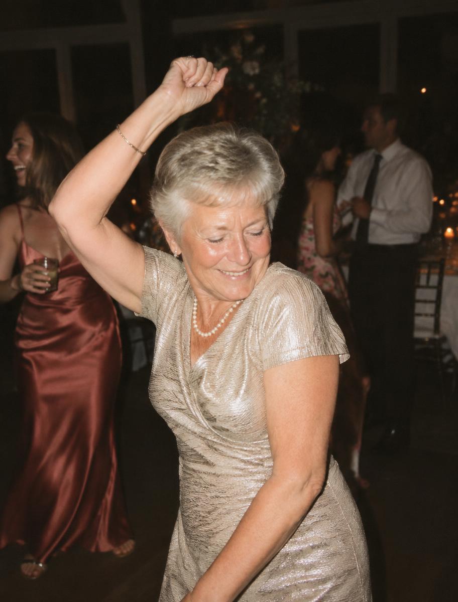 An older guest dancing joyfully on the reception dance floor